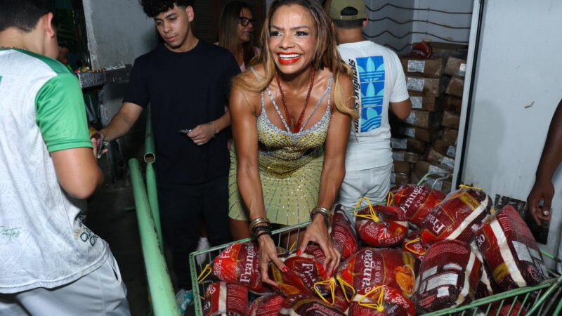 A rainha de bateria Quitéria Chagas promove ação social distribuindo chesters aos ritmistas da Império Serrano.